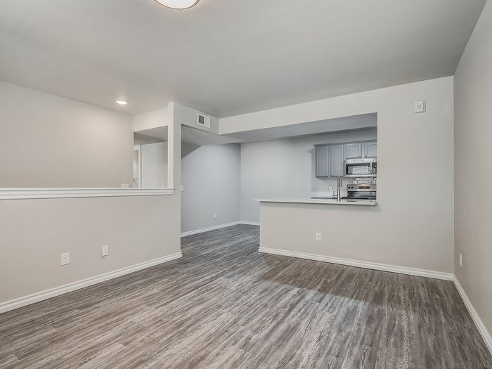 Bright and spacious open-concept living area with stylish flooring and a modern kitchen.