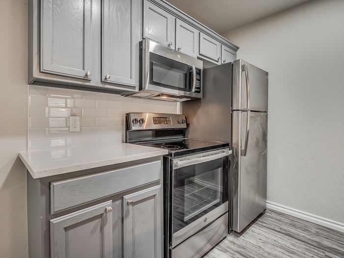 Contemporary kitchen with stainless steel appliances and chic grey cabinetry.