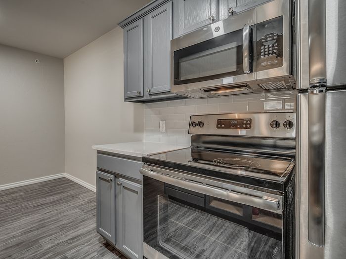 Modern kitchen with sleek stainless steel appliances and elegant gray cabinetry.