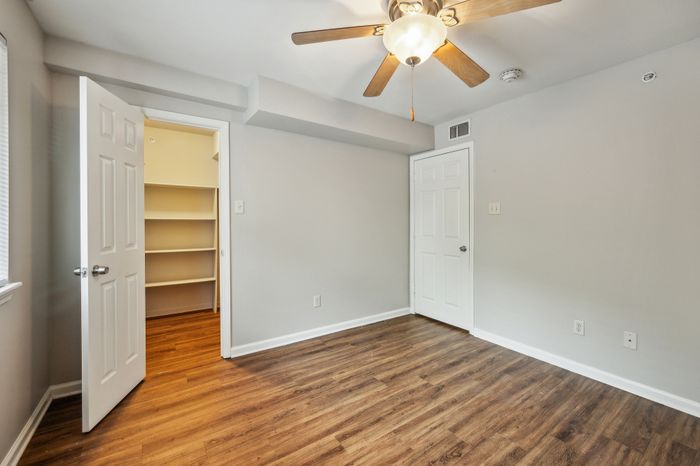 Bright room with sleek hardwood floors, two doors, and a spacious open closet, perfect for stylish living.