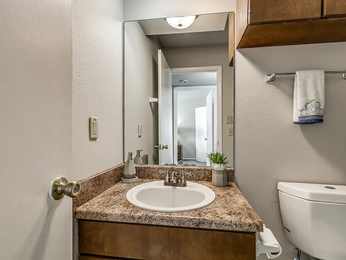 Inviting bathroom with elegant granite countertop, modern sink, and stylish lighting, creating a cozy and functional space.