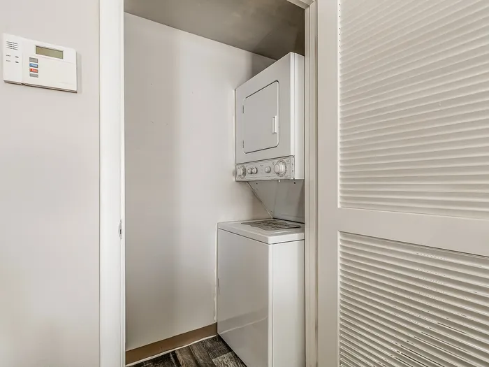 Modern in-unit laundry area with a compact stacked washer and dryer, maximizing space and convenience.