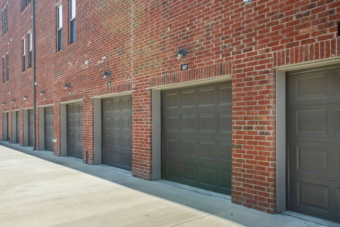 Charming brick apartment building with multiple garage doors, offering ample parking space and convenient accessibility.