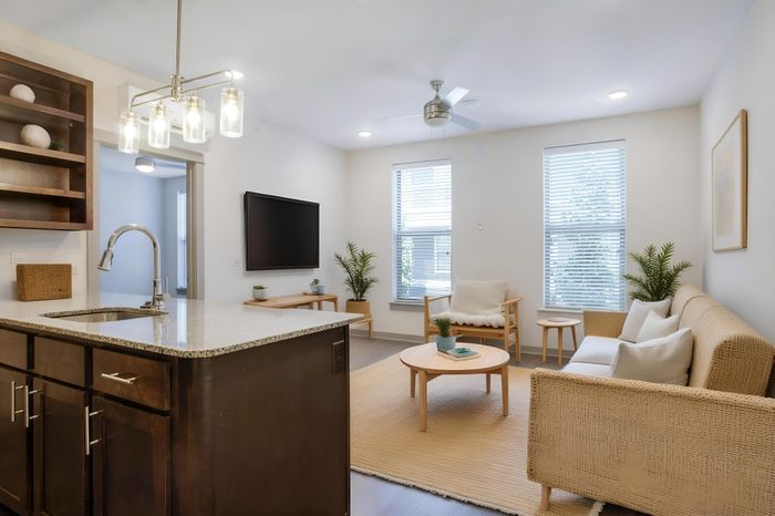 Elegant modern living room with a stylish open kitchen, cozy seating, and tasteful decor creating a warm and inviting atmosphere.