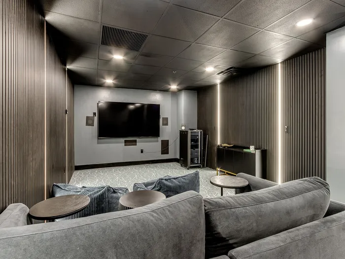 Modern home theater with plush seating, sleek decor, and a large flat-screen TV for an immersive entertainment experience.