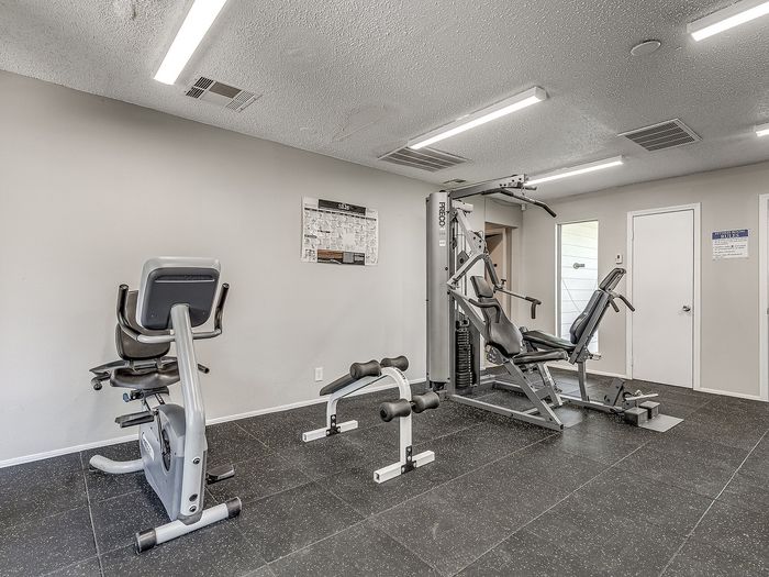 Contemporary fitness room featuring modern exercise equipment and sleek flooring, perfect for a healthy lifestyle.