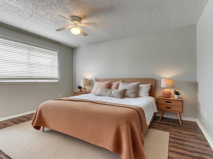 Cozy bedroom with a warm ambiance, featuring a stylish bed with plush pillows, wooden nightstands, and ambient lighting.