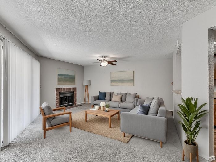 Inviting living room with modern gray sofas, cozy fireplace, and stylish decor, perfect for relaxation and entertainment.