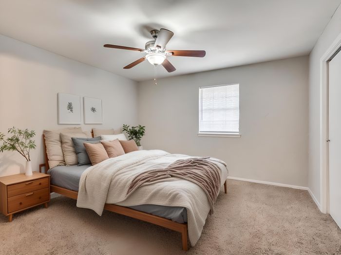 Serene bedroom with cozy bed, plush pillows, soft lighting, and elegant ceiling fan for a relaxing retreat.