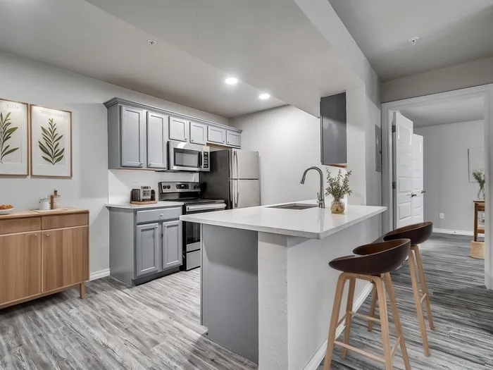 Modern kitchen with sleek cabinetry, stainless steel appliances, and a cozy breakfast bar with elegant seating.