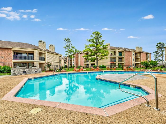 Inviting apartment complex with modern architecture and a sparkling swimming pool, perfect for relaxation and leisure.