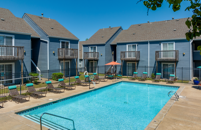 Charming apartment complex with a refreshing outdoor pool, surrounded by cozy balconies and sun loungers, perfect for relaxation and leisure.