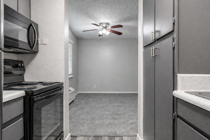 Charming modern kitchen with sleek appliances and adjacent cozy dining area featuring a stylish ceiling fan.