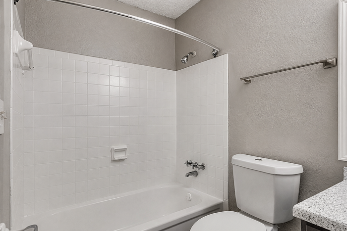 Modern bathroom featuring a sleek bathtub with chrome fixtures and elegant white tiles.