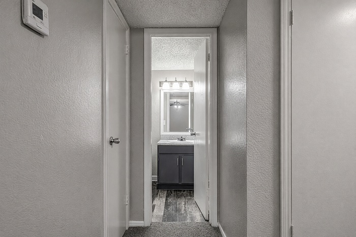 Bright hallway leading to a modern bathroom with stylish fixtures, enhancing a contemporary apartment feel.