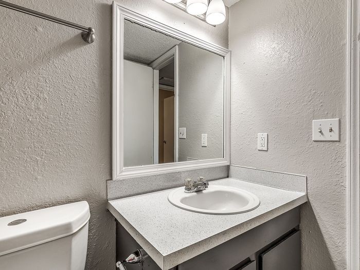 Sleek and modern bathroom with a polished vanity, large mirror, and ambient lighting, perfect for a refreshing start to your day.