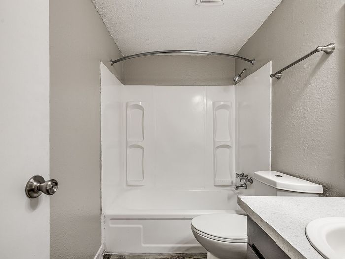 Modern bathroom with chic white bathtub, elegant fixtures, and sleek design.