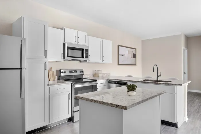 Modern kitchen with elegant white cabinetry, sleek stainless steel appliances, and stylish granite countertops.