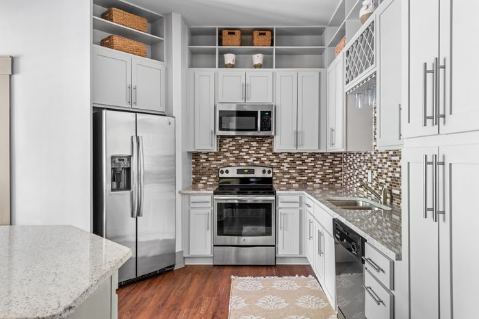 Modern kitchen with sleek stainless steel appliances, elegant white cabinetry, and a stylish tile backsplash.