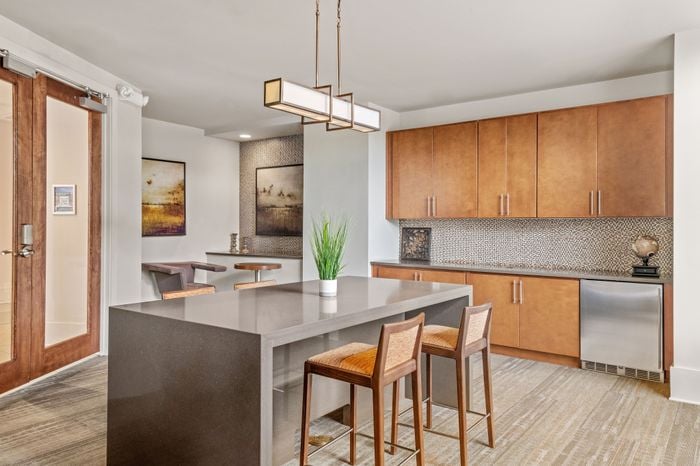 Modern kitchen with elegant brown cabinetry, sleek countertops, and chic pendant lighting, perfect for culinary enthusiasts.