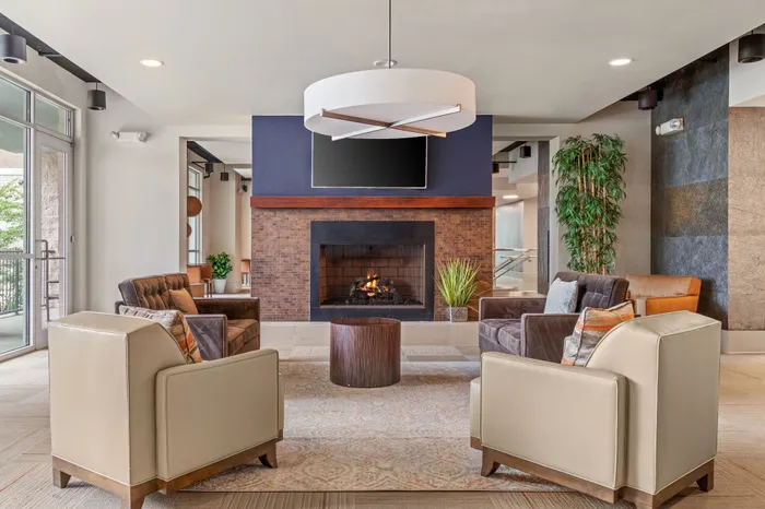 Chic and inviting lounge area featuring a luxurious fireplace, stylish seating, and elegant lighting.
