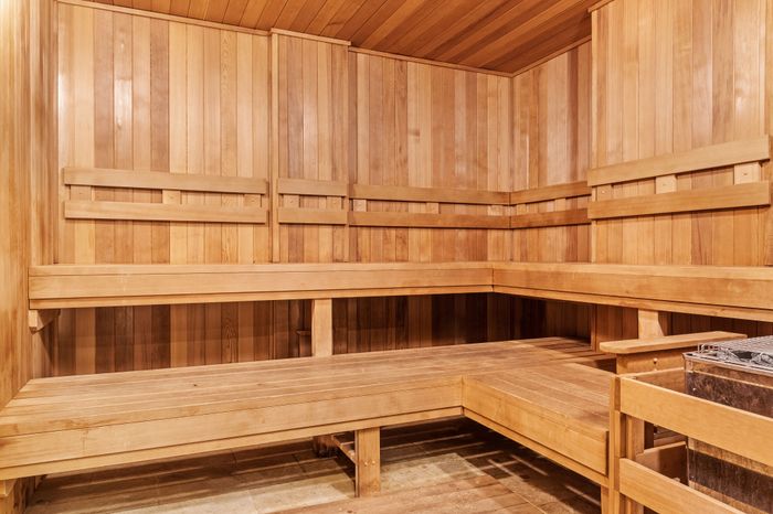 Luxurious cedar sauna with warm lighting and spacious seating, perfect for relaxation and rejuvenation.