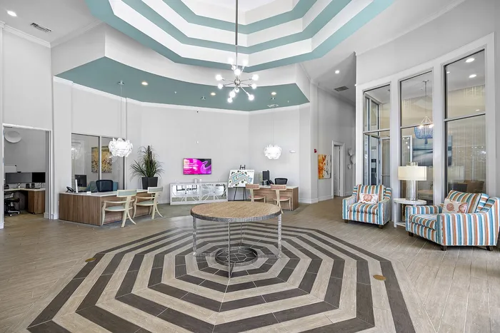 Inviting lobby with modern design, featuring stylish seating, vibrant decor, and a striking geometric floor pattern.