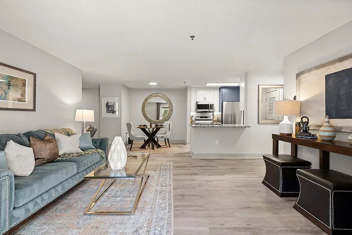 Contemporary open-concept living and dining area with elegant furnishings, plush seating, modern kitchen, and decorative accents.