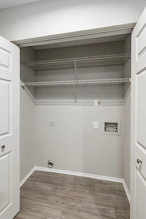 Contemporary utility closet with wire shelving and hardwood floors, ready for customizable storage solutions.