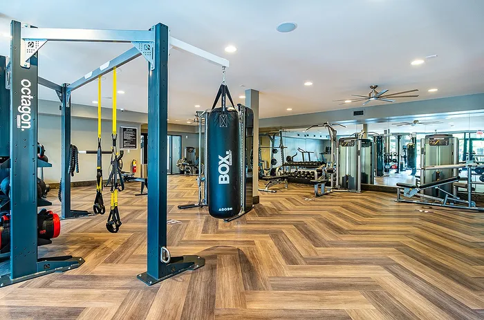 Modern fitness center with state-of-the-art equipment and stylish wood flooring.
