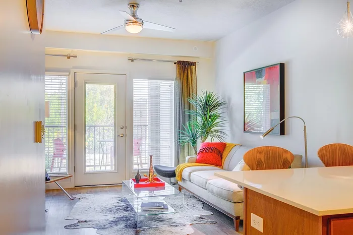 Apartments near TRAX Millcreek, UT - VIA - Spacious Living Room, Large Windows, High Ceilings, Ceilings Fans, and Windowed Door to Private Balcony