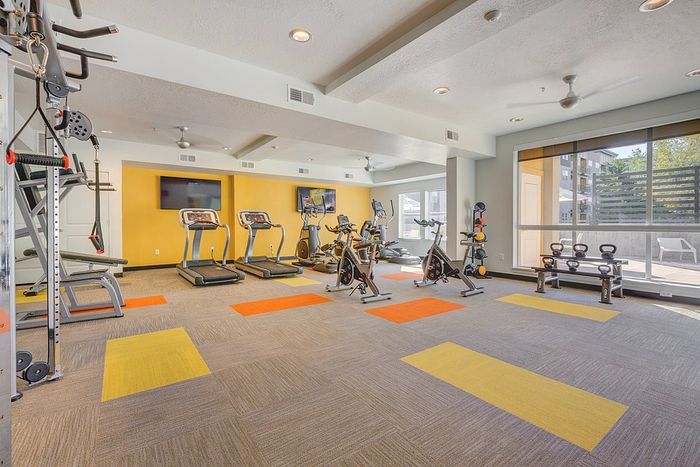 Studio Apartments in Millcreek UT - ViA - Fitness Center with Cadio Machines, Cable Machines, Free Weights, TVs, and Stationary Bikes.