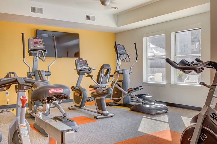 Bright, state-of-the-art fitness center with modern exercise equipment and ample natural light.