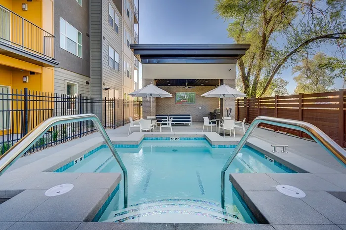Inviting outdoor area with a modern swimming pool, sun loungers, and stylish umbrellas, perfect for relaxation and leisure.