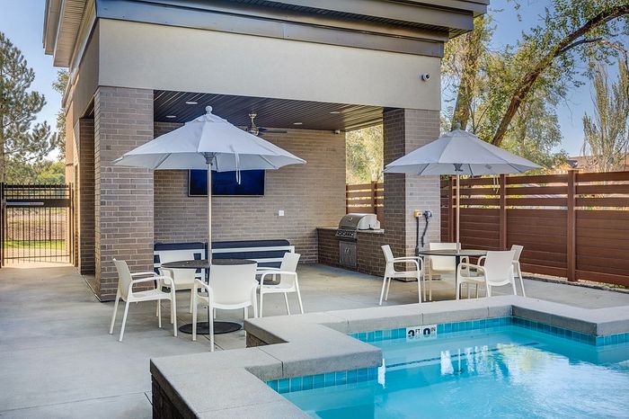Elegant outdoor patio with a luxurious pool, stylish seating areas, and a modern barbecue setup, perfect for entertaining.
