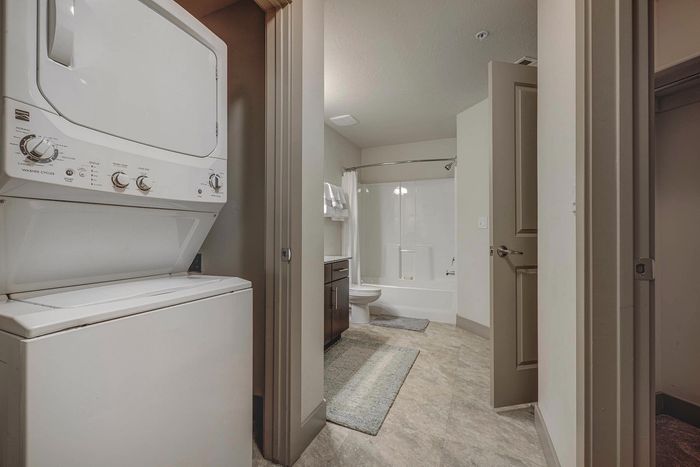 Modern apartment interior featuring a sleek bathroom with an integrated laundry area, highlighting convenience and style.