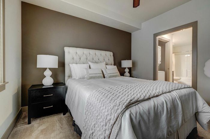 Inviting bedroom with elegant decor, featuring a plush bed, stylish nightstands, and modern lighting in a serene atmosphere.