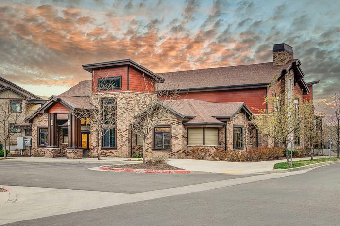 Sandy, UT Apartments For Rent - Dry Creek - Leasing Office With A Parking Lot Surrounded By Branches