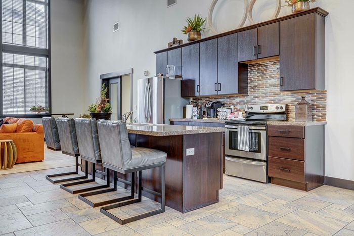 Modern kitchen with sleek cabinetry, high-top chairs, and stainless steel appliances, perfect for stylish living.