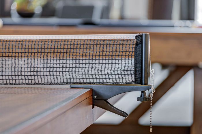 Chic and modern table tennis setup in an elegant apartment, showcasing a stylish wooden table with a sleek net.