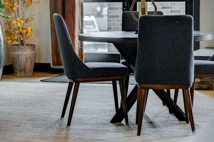 Elegant dining space with modern gray chairs and a round table, accented by stylish decor and natural light.