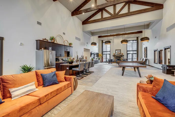 Two-Bedroom Apartments In Sandy, UT - Dry Creek - Resident Clubhouse With A Kitchen Area, Ping Pong Table, Fireplace, Couch Seating, Tables, Chairs, And A PAC-MAN Video Game