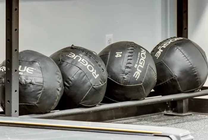 Contemporary gym equipment featuring neatly stacked Rogue medicine balls for a dynamic workout space.