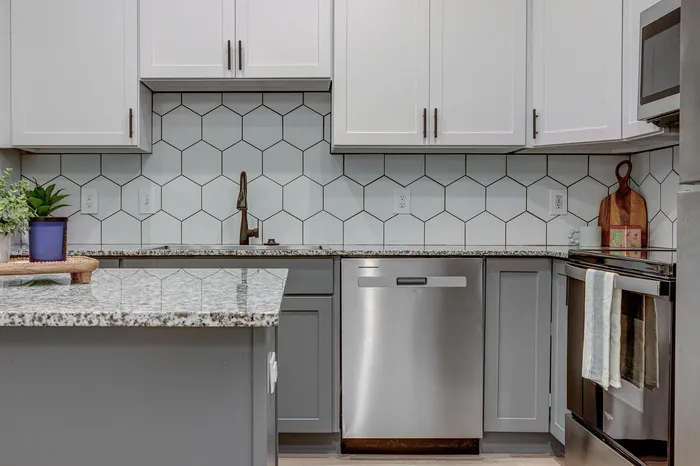 Chic modern kitchen with sleek cabinetry, stainless steel appliances, and stylish hexagonal backsplash.