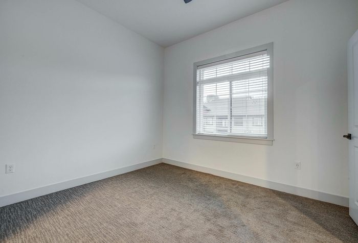 Inviting bedroom space with plush carpeting and a large window offering abundant natural light.