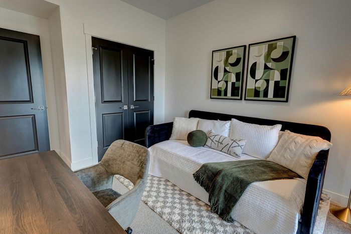 Chic home office with a plush daybed, abstract wall art, and a cozy workspace vibe.