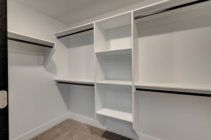 Spacious walk-in closet with ample shelving and hanging space, perfect for organized storage solutions.