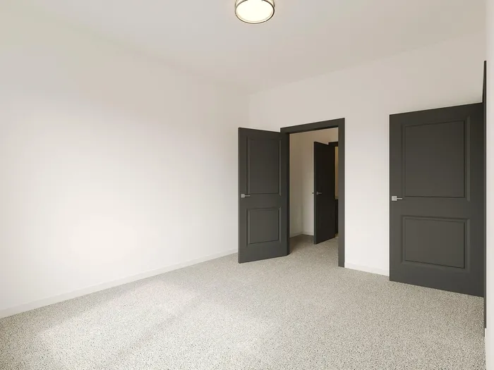 Bright, spacious room with stylish dark double doors and inviting neutral carpet.