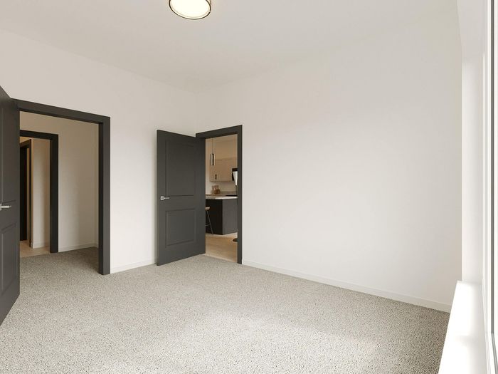 Bright and airy room with plush carpet, modern dark doors, and a glimpse into a sleek kitchen, perfect for contemporary living.