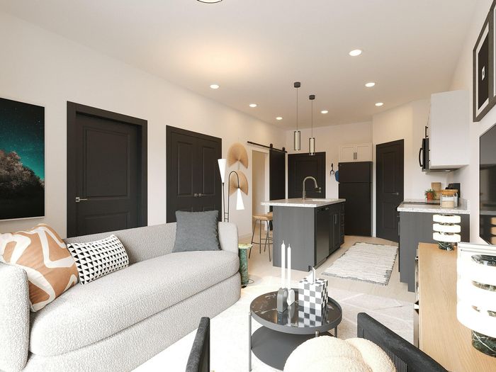 Chic open-concept living space featuring a cozy sofa, stylish modern kitchen island, and elegant decor accents under warm lighting.
